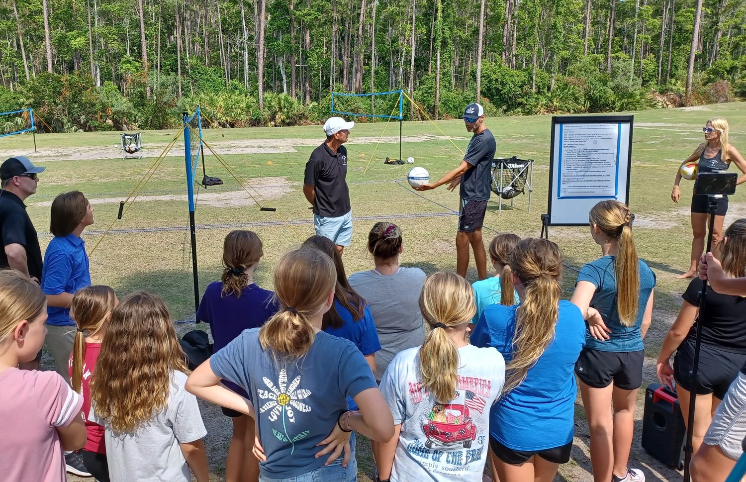 Olympic gold medalist Phil Dalhausser discusses technique with a youth volleyball class at Nocatee Community Park. Looking on are Andor Gyulai, left, and Vanessa Summers-Gyulai, right.